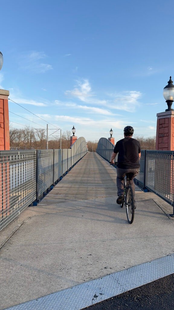 Bespoke Bikeways' Brandon rides across a bridge along the MetroBikeLink Trail.
